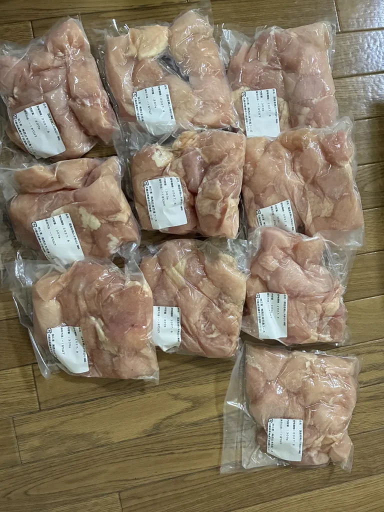 床に並べた、鶏むね肉の袋10パック。どの袋にも角切りの肉が入っている