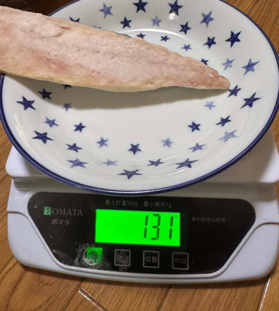皿にのせたさばのフィーレ1枚を、はかりではかると131グラム